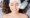 Top view of beautiful young woman with closed eyes wearing white headband while receiving facial treatment in cosmetology clinic. Charming female patient having face lifting procedure and smiling.